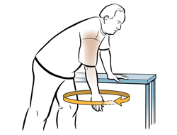 Man bending forward with one hand on table for support, swinging other arm in circle doing shoulder exercise.