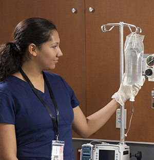 Healthcare provider checking IV bag.